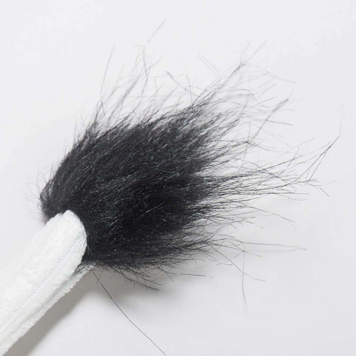 Dottie Cow Knottie close-up of the fuzzy black tuft at the end of its white corduroy tail