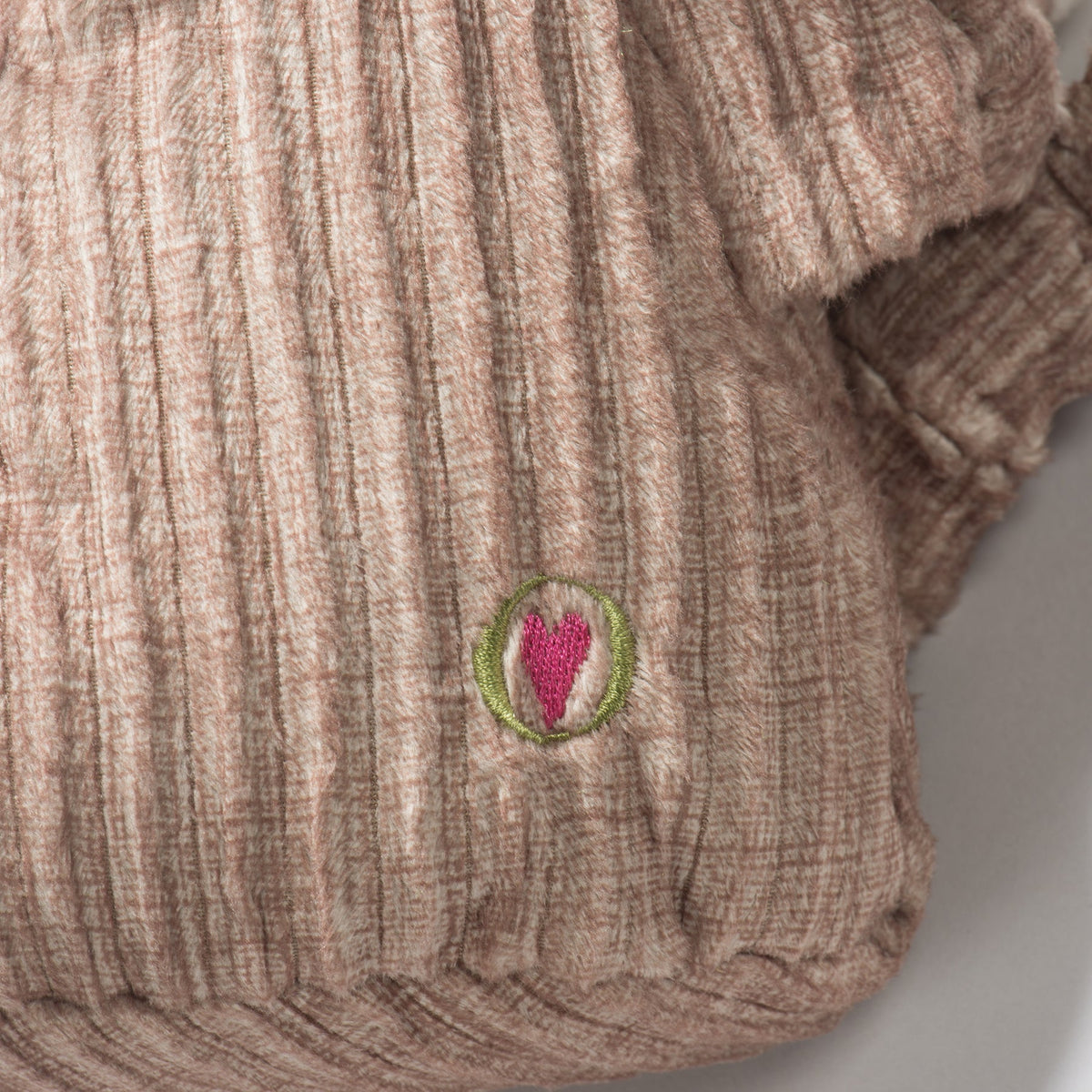 Stuey Sock Monkey Knottie close-up of the embroidered pink heart logo on its brown corduroy body