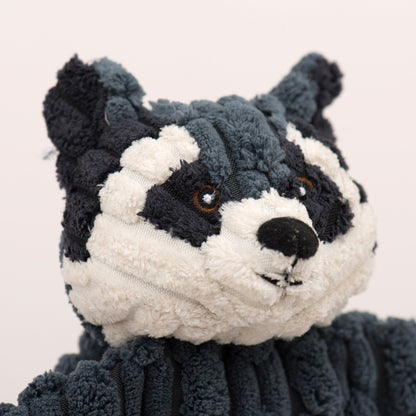 Close-up of the raccoon Flattie's face, cream and charcoal plush with embroidered eyes and a black nose