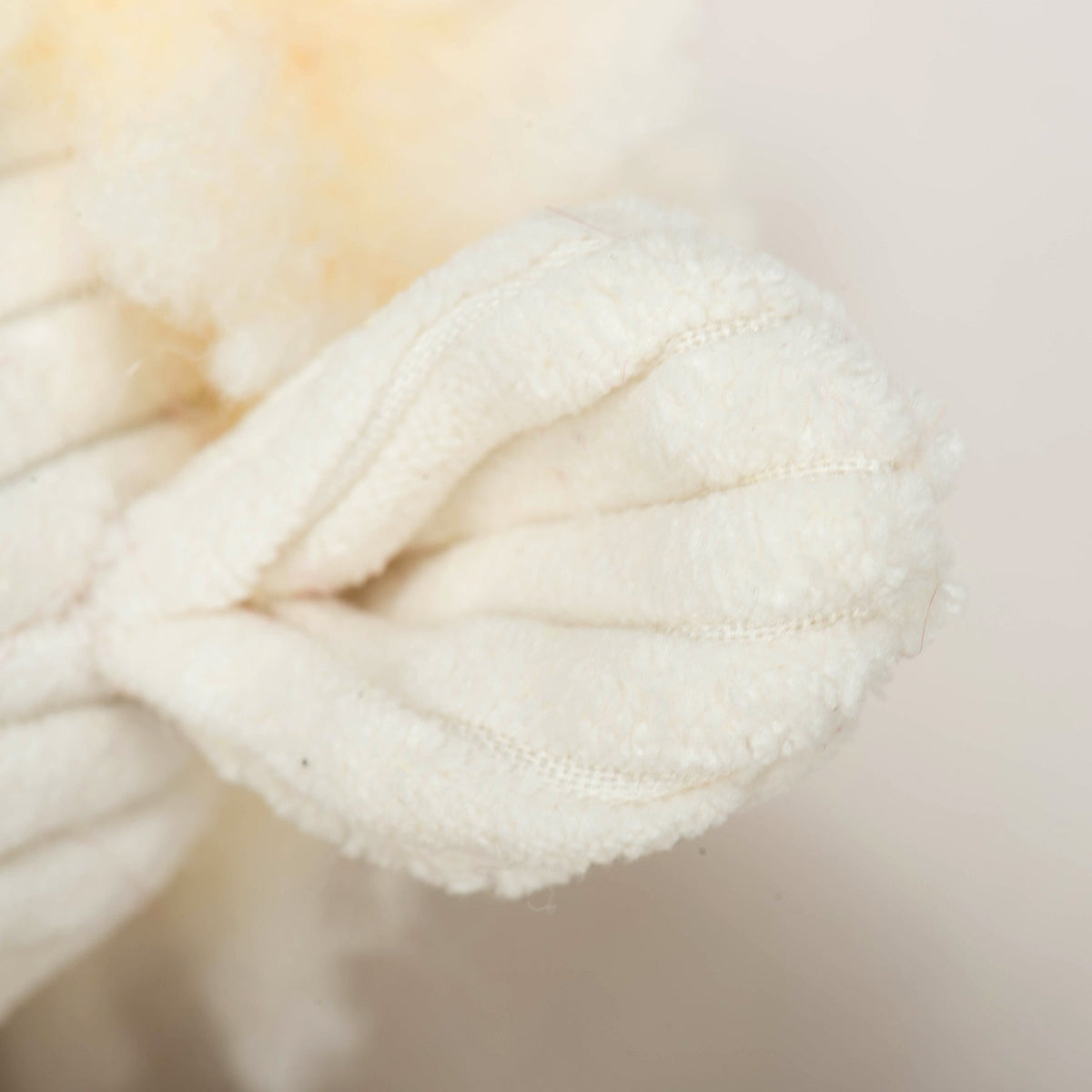 Louise Lamb plush close-up of a ribbed cream corduroy paw against her fleece body