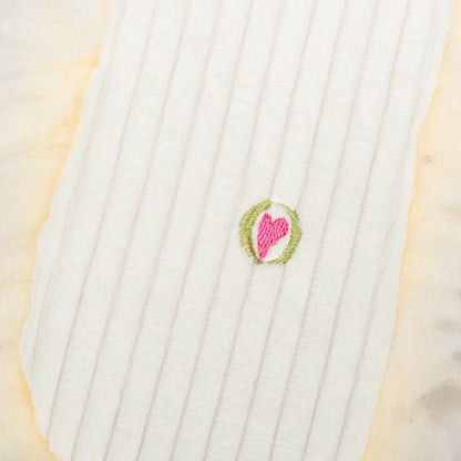 Louise Lamb plush close-up of the small embroidered pink heart logo on her corduroy back