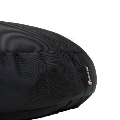 Close-up of the Round Armor dog bed's black ballistic nylon weave and American Dog label