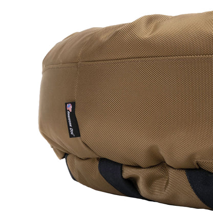 Round Bolstered Armor dog bed in camel, side close-up with the American Dog label and black non-skid strips below