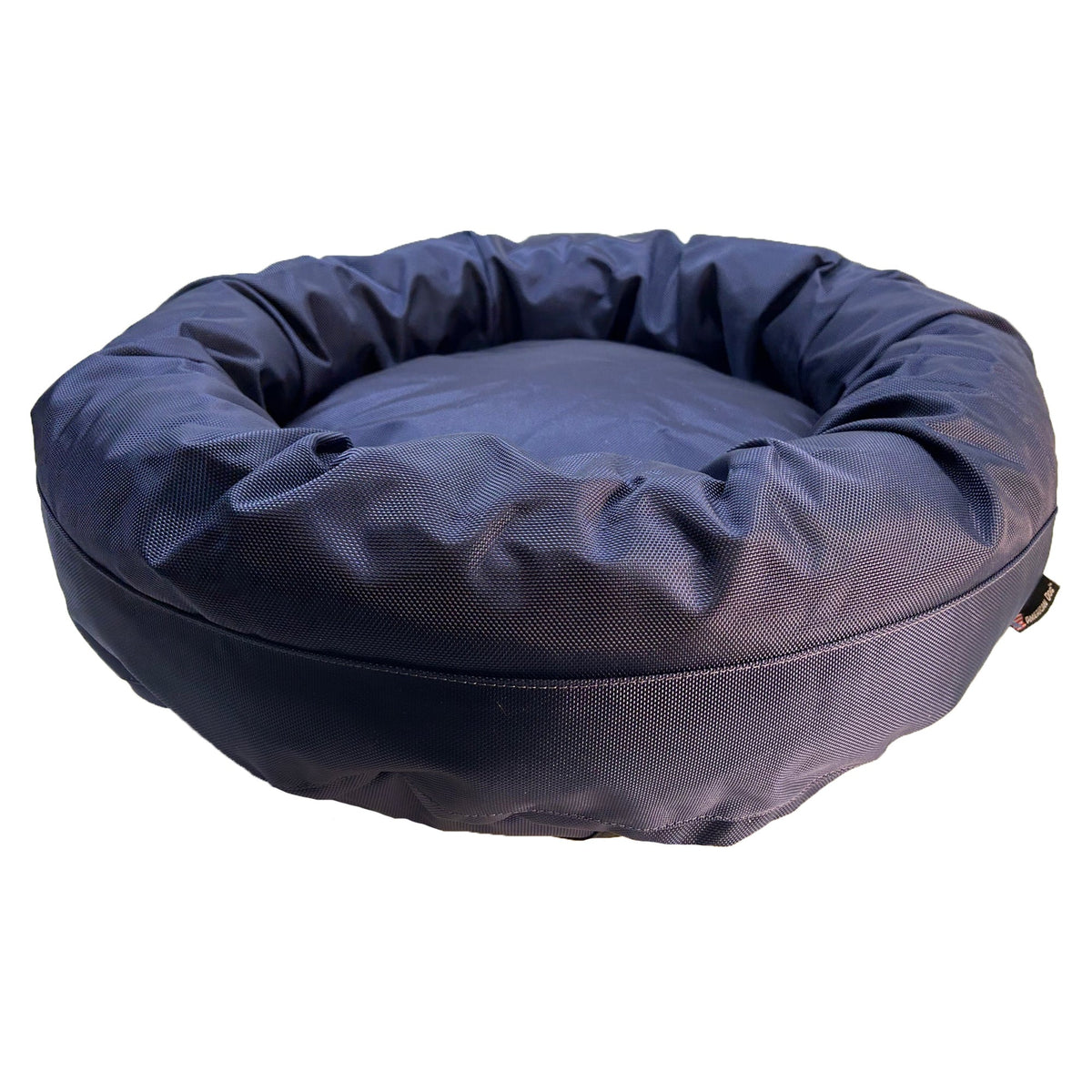 Round Bolstered Armor dog bed in midnight navy, side view with the American Dog label