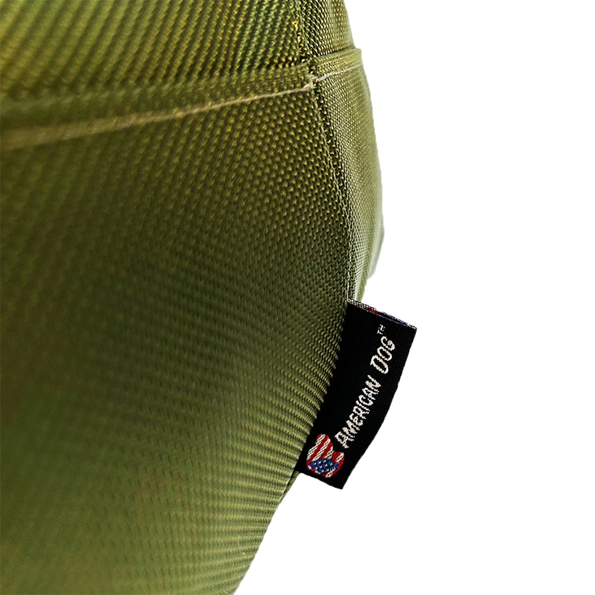 Round Bolstered Armor dog bed in olive, close-up of the ballistic nylon weave and American Dog label