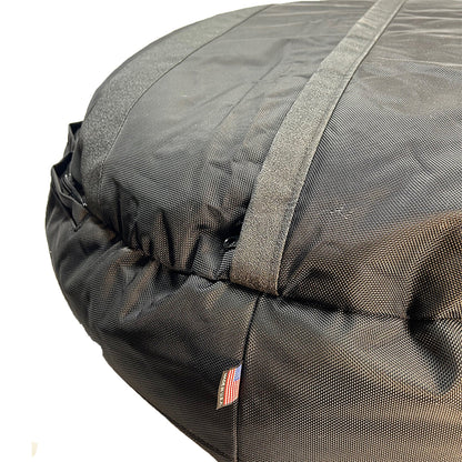 Round Bolstered Armor dog bed in black, underside close-up with non-skid strips, zipper and Made in USA flag tag