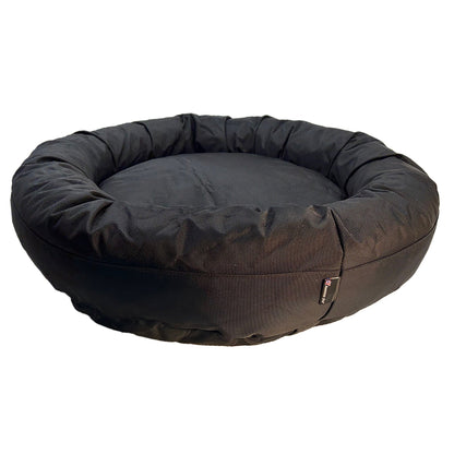 Round Bolstered Armor dog bed in black, side view of the gathered rim and American Dog label