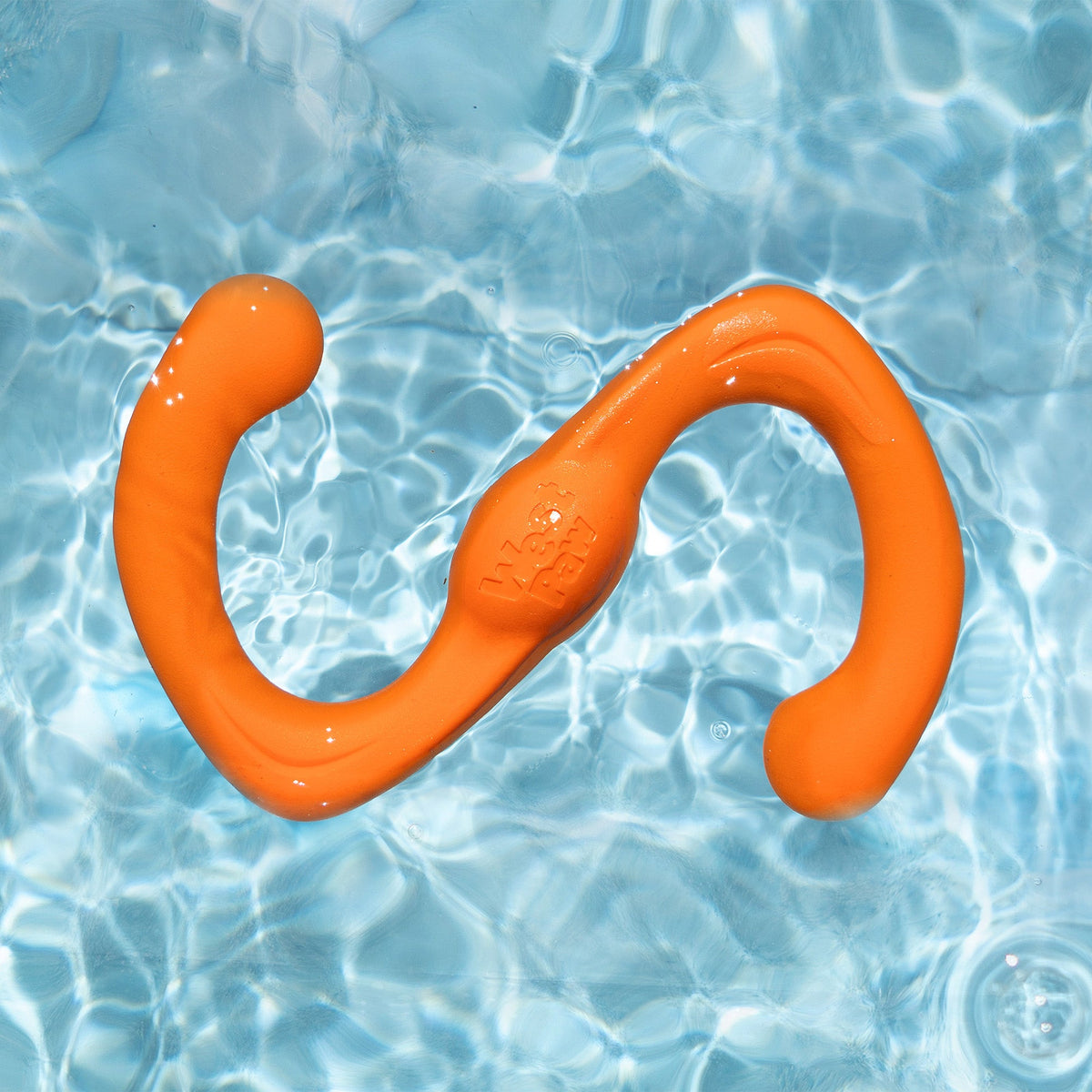 Tangerine Bumi tug toy floating in clear pool water