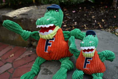 Albert Gator Knottie dog toy in two sizes sitting on a stone step outdoors