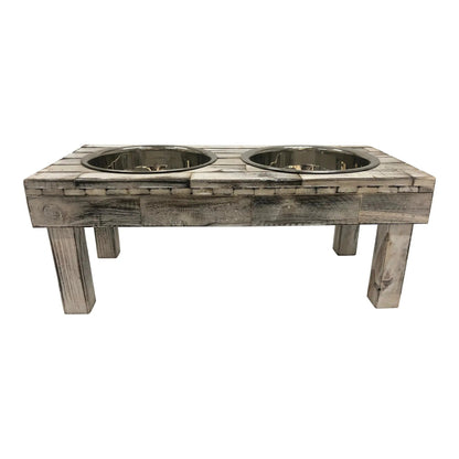 White wash wooden raised dog feeder seen straight on from the front, showing the legs and both bowl rims