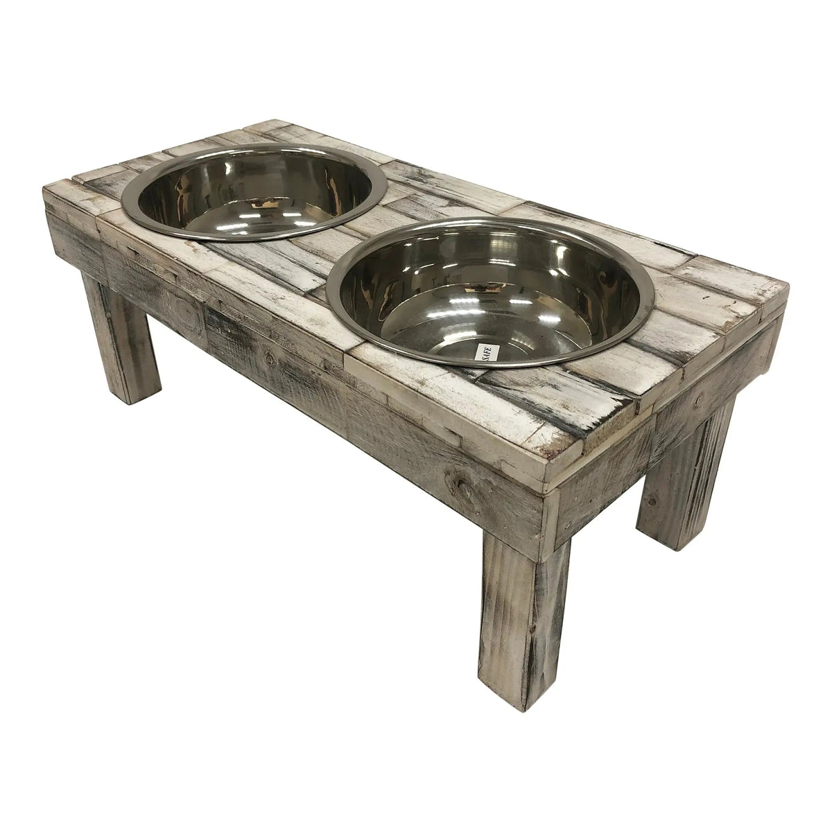 White wash raised double bowl dog feeder from a high corner angle, both stainless bowls set into the top
