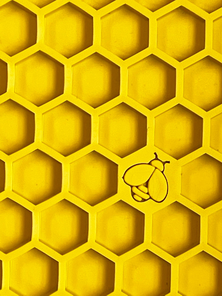 Close-up of the yellow SodaPup Honeycomb eMat surface showing the hexagon cells and embossed bee