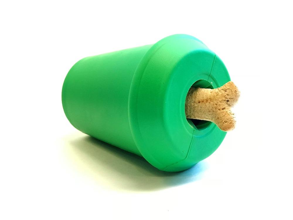 Coffee Cup treat dispenser on its side with a bone-shaped dog biscuit wedged in the lid opening