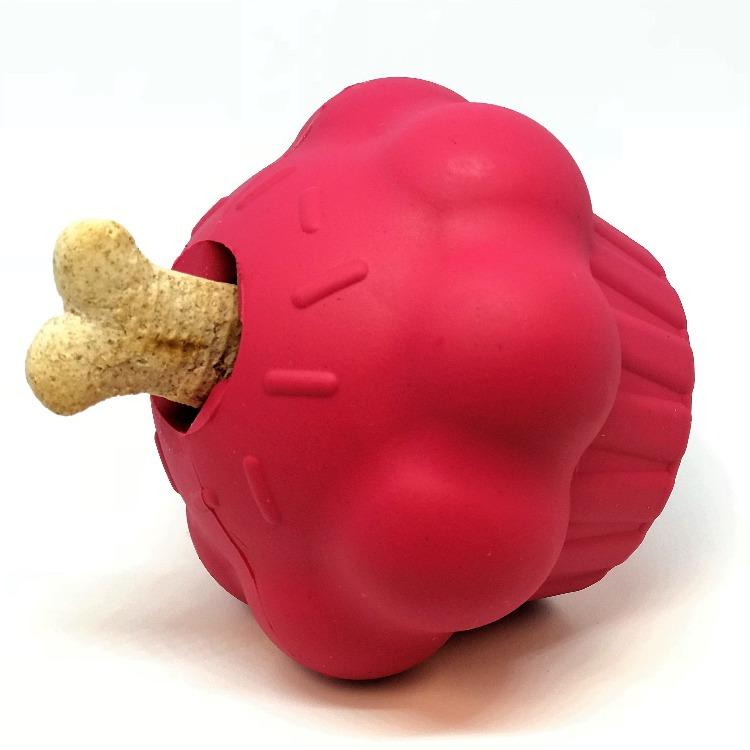 Cupcake treat dispenser tipped on its side, a dog biscuit poking out of the opening in the frosting
