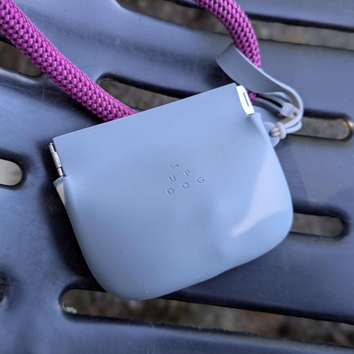 Up Dog One-Hand Treat Pouch in gray hanging from a magenta rope leash over a dark park bench