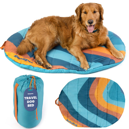 Packable travel dog bed in Sunset Surf Teal, Medium, with a golden retriever lying on it and the rolled carry sack