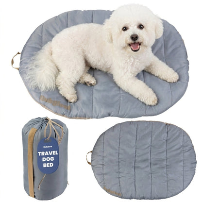 Packable travel dog bed in Foggy Trail Grey, Small, with a bichon on it and the gray carry sack with tan strap