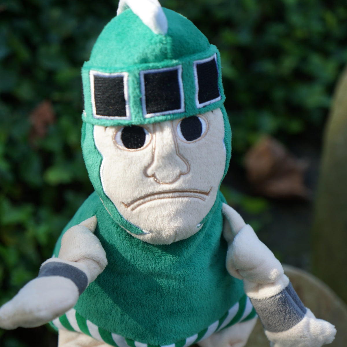 Sparty Knottie dog toy close-up outdoors, stern stitched face under the green helmet's black visor