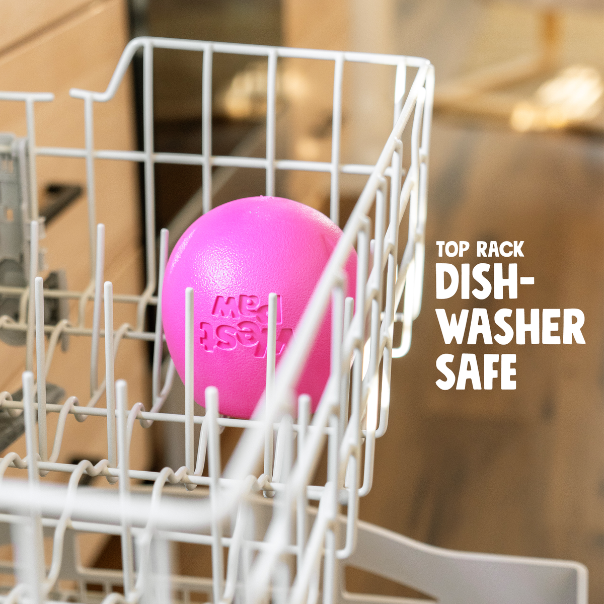 Rumbl treat dispenser in hot pink sitting in the top rack of a dishwasher