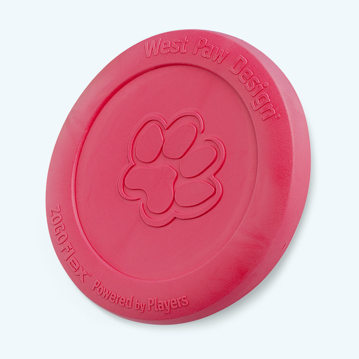 West Paw Zisc flying disc in ruby red, standing on its edge with the paw print facing forward