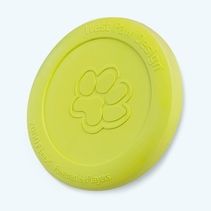 Green West Paw Zisc flying disc upright on its edge, showing the Zogoflex lettering along the rim