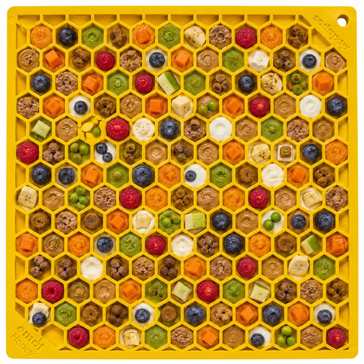 Large yellow SodaPup Honeycomb eMat with blueberries, raspberries, carrot cubes, peas, and soft food in the cells