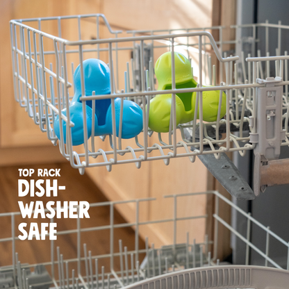 Tux treat toys in aqua blue and granny smith green in the top rack of a dishwasher