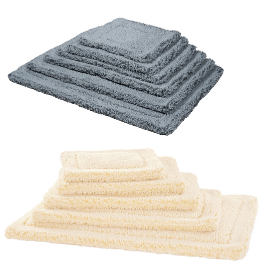HuggleFleece washable dog mats stacked by size in gray and in natural cream, five sizes each