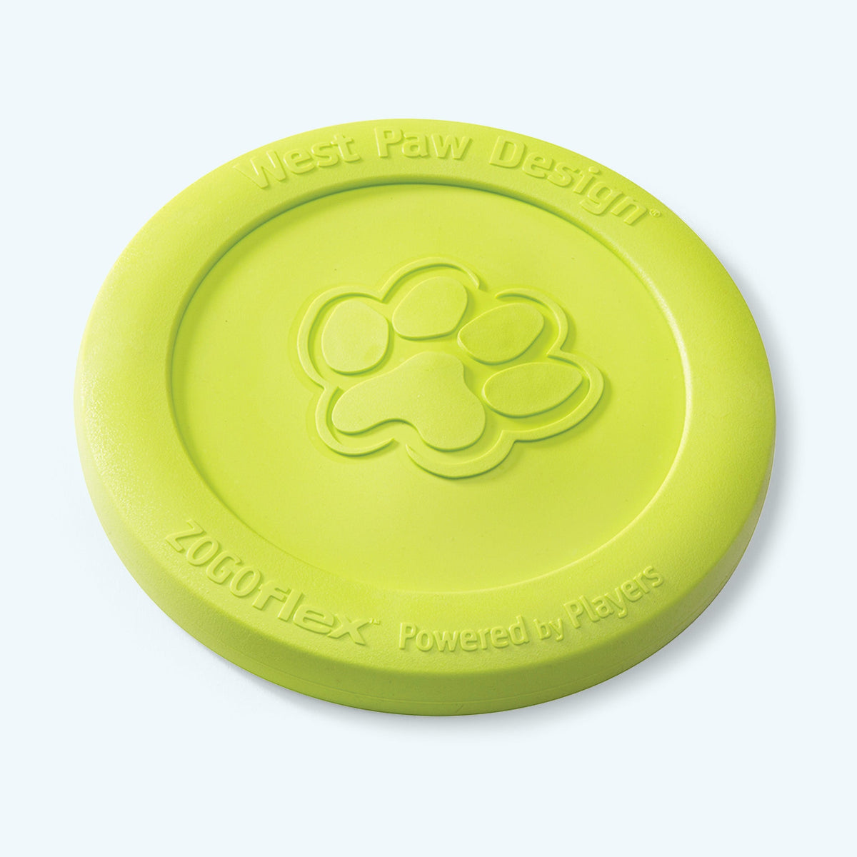 West Paw Zisc flying disc in granny smith green, lying flat at an angle with the embossed paw print