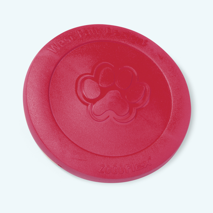 West Paw Zisc flying disc in ruby red, lying flat at an angle with the embossed paw print