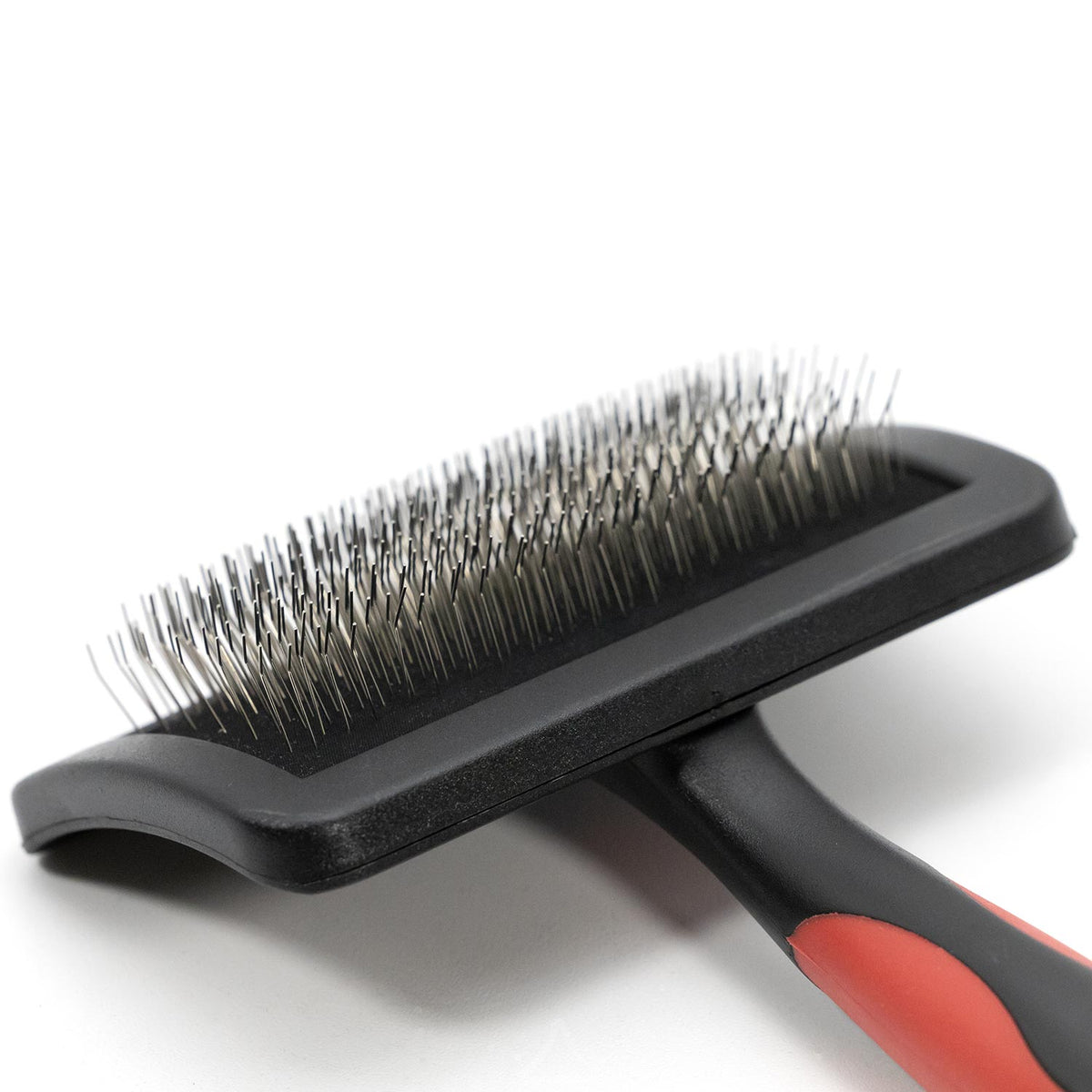 Side close-up of the Jeffers dual-level slicker brush, showing long and short pins on the curved head