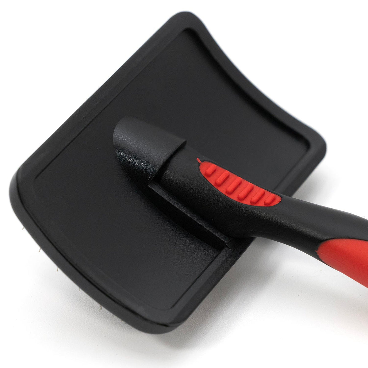 Back of the Jeffers slicker brush head, showing its curved shape and red thumb rest on the handle