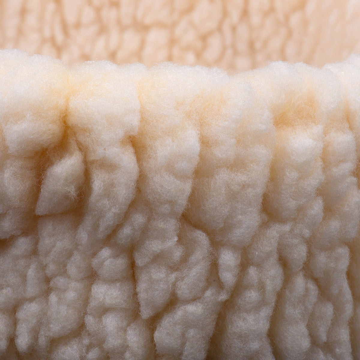HuggleSnuggler fleece bed close-up of the gathered rim, dense curly cream fleece