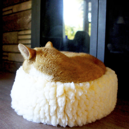 HuggleSnuggler fleece bed with an orange cat curled up asleep inside, seen from behind