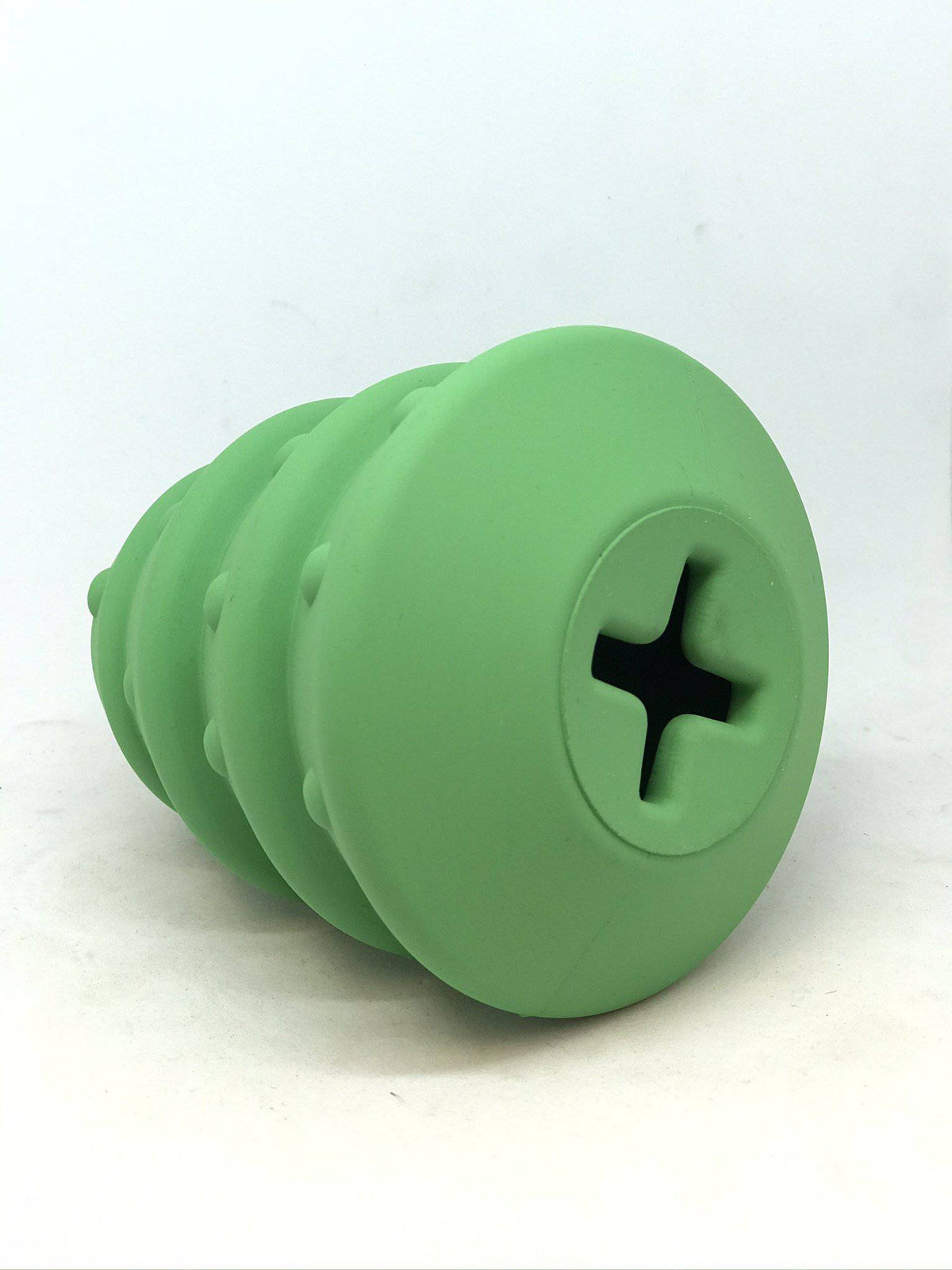 Christmas Tree treat dispenser tipped toward the camera, showing the cross-cut fill opening in its flat base